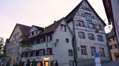 Wangen im Allgu, Almanya, 17 Ağustos 2023. Mavi saatte çekilen tava hareketi, insanların akşamları toplandığı meydanda koşuyor. Sağda yarım keresteli bir ev var..