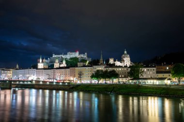 Salzburg, Avusturya, 15 Ağustos 2022. Nehre bakan tarihi merkezin büyüleyici gece çekimi. Arkada, tepede, kalede. Boşluğu kopyala.