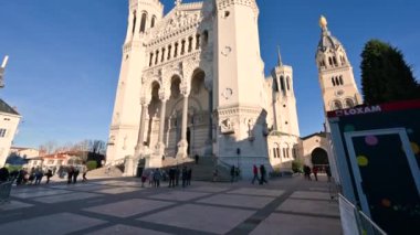 Lyon, Fransa, 27 Aralık 2023. Notre-Dame de Fourvire Bazilikası 'nın görüntüsü çok güzel. Öğleden sonranın sıcacık ışığı yüzümüzü aydınlatıyor. İnsanlar kilise bahçesinde yürüyor..