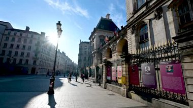 Lyon, Fransa, 27 Aralık 2023. Komedi Meydanı 'ndaki belediye binasının arka girişinin görüntüsü. Güneş solda parlıyor. Yürüyen insanların geçişi.
