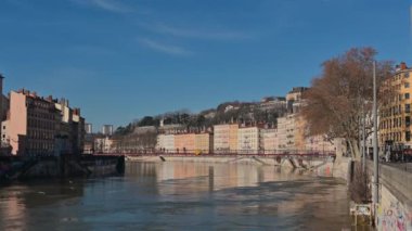 Lyon, Fransa, 27 Aralık 2023. Quai Saint Vincent Riverfront 'a yakınlaşan güzel görüntüler: renkli cepheli evler şehir manzarasını karakterize eder. Kızıl Saint Vincent yaya köprüsü.