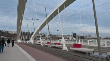 Lyon, Fransa, 27 Aralık 2023. Modern Raymond Barre köprü yapısının eğik görüntüleri. İnsanlar onun üzerinde yürüyor..