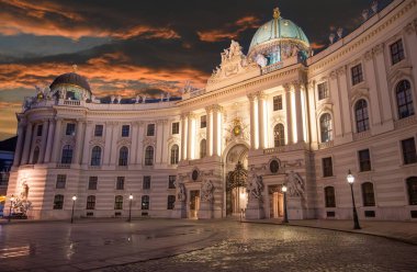 Viyana, Avusturya, 17 Ağustos 2022. Hofburg İmparatorluk Sarayı 'nın muhteşem gece manzarası. Aydınlanma heybetli görünüşü artırıyor. Meydandaki insanlar.