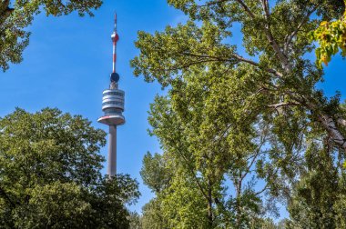 Viyana, Avusturya, 17 Ağustos 2022. Tuna Kulesi veya Donauturm, Avusturya 'nın 252 metre yüksekliğindeki en yüksek binasıdır. Parkın ağaçlarının arasında duruyor..