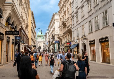 Viyana, Avusturya, 18 Ağustos 2022. Alışveriş caddesi: Moda markaları görülebilir, cadde insanlarla dolu. Arka planda, Sisi Müzesi 'nin girişi olan Michaelerplatz Meydanı Hofburg.