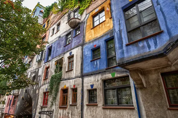 stock image Vienna, Austria, August 21, 2022. Spectacular shot of the colorful facade with plants and trees of the Hundertwasser house in Vienna. Residential building, with apartments.