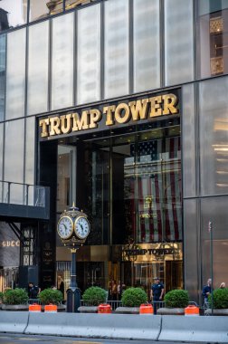 New York, New York, ABD. 17 Ağustos 2024. Trump Tower 'ın girişinde klasik saat ve altın harfler bulunur. Camın arkasında büyük bir Amerikan bayrağı var..