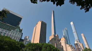 New York, ABD, 14 Ağustos 2024. Central Park 'taki ağaçların çerçevelediği gökdelenlerin çarpıcı görüntüleri. Dönüyor, güzel yaz günü.