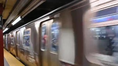 New York, ABD, 15 Ağustos 2024. Metro treninin yakın çekim görüntüsü istasyonda duruyor, yolcular içeride. Arabalardaki Amerikan bayrakları işaretlenmiş..