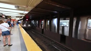 New York, ABD, 16 Ağustos 2024. Metro durağındaki yavaş çekim görüntüleri: trenin gelişini ve platformdaki insanların trene binmek için hareket ettiğini görebiliyoruz..