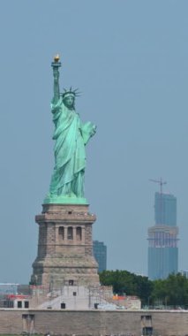 New York, ABD, 16 Ağustos 2024. Tekneyle yanından geçerken Özgürlük Anıtı manzaralı büyüleyici dikey görüntüler. Turistler adada gezmek için görülebilir..