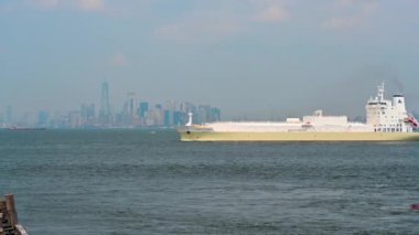 New York, ABD, 16 Ağustos 2024. Arka planda Manhattan 'ın ikonik görüntüsü, körfezin sisi ve çerçevenin içinden geçen büyük bir gemi. Seyahat yerleri.