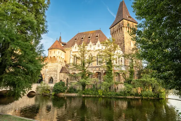 Budapeşte, Macaristan. 27 Ağustos 2022. Geniş açılı çekim, Vajdahunyad Kalesi 'ne bakıyor. Sıcak öğleden sonra ışığı ön tarafı aydınlatıyor. Peri masalı atmosferi, seyahat yerleri.