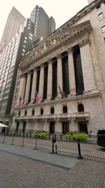 New York, ABD, 16 Ağustos 2024. Borsanın bulunduğu binanın ön cephesinin dikey görüntüsü. Girişi çevreleyen Amerikan bayrakları işaretlendi. İnsanlar fotoğraf çekiyor..