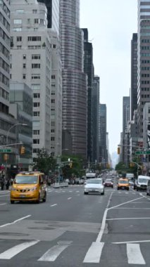 New York, ABD, 17 Ağustos 2024. Manhattan 'da işlek bir caddenin dikey görüntüsü. Özel arabalar ve sarı taksiler hızla geçiyor. Ön planda, yaya geçidi..
