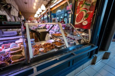 Budapeşte, Macaristan. 29 Ağustos 2022. Kapalı piyasa, işlenmiş et ve pişirilmiş et satıcısı tezgahının ayrıntıları. Çeşitli kesikler etiket ile türünü ve fiyatını gösterir.