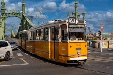 Budapeşte, Macaristan, 29 Ağustos 2022. Güzel bir yaz gününde, Liberty Köprüsü manzarası toplu taşıma hizmetinin klasik tramvaylarından biriyle kesişiyor. Şehrin ikonik görüntüleri.