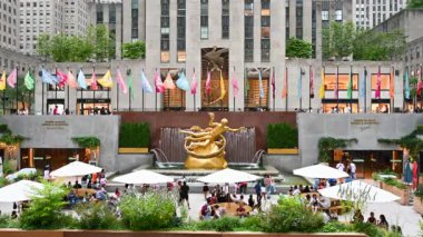 New York, ABD, 18 Ağustos 2024. Rockefeller Center 'ın görüntüsü, şehir hayatının merkezi. Masalarda şemsiyeli insanlar, alışveriş merkezini ziyaret edenler. Seyahat yerleri.