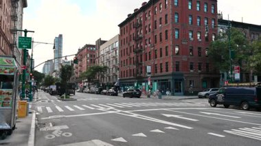 New York, ABD, 19 Ağustos 2024. Columbus 'un sokak manzarası. Bize yakın eski kırmızı tuğlalı binalar ve Manhattan 'ın gökdelenleri. Yoldan geçen arabalar ve kaldırımlarda insanlar. Seyahat yerleri.