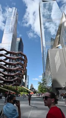 New York City, ABD, 20 Ağustos 2024. Şehirde yeni bir dönüm noktası olan modern gemi yapısını gösteren dikey görüntüler. Seyahat yerleri. Halka açık alanda yürüyen insanlar.