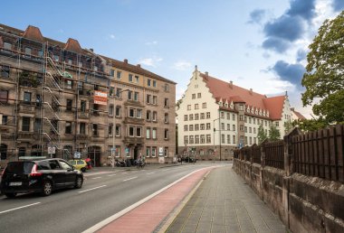 Nuremberg, Almanya, 1 Ağustos 2023. Bir bisiklet yolu, arka planda tipik mimarisi olan bir ev. Yoldan arabalar geçiyordu. Şehirde hayat..