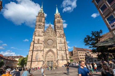 Nuremberg, Almanya, 1 Ağustos 2023. Güneşli bir günde St. Lorenz Kilisesi 'nin güzel bir fotoğrafı. Mavi gökyüzünde beyaz bulutlar dolaşıyor, insanlar kilisenin önünden geçiyor. Seyahat yerleri.