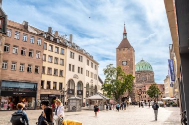 Nuremberg, Almanya, 1 Ağustos 2023. Tarihi merkezde şehir hayatı. Beyaz kulenin arka planında Ehekarussell çeşmesi ayaklarının altında, insanlar bu güzel yaz gününde geziniyorlar..