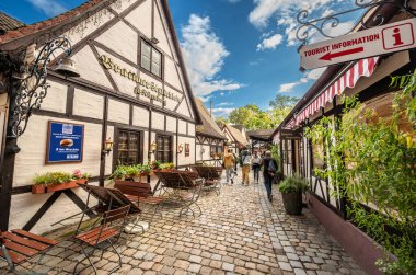 Nuremberg, Almanya, 1 Ağustos 2023. Tarihi şehir duvarları içinde, antik dükkanların zarif bir yeniden inşası artık restoranlara ve barlara ev sahipliği yapıyor. İnsanlar yürüyor ve masalara oturuyorlar. Şehir hayatı.