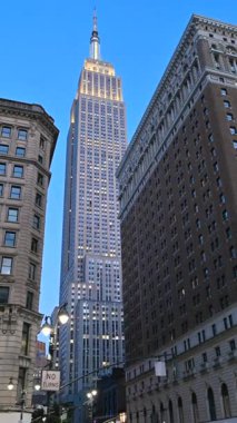 New York City, ABD, 20 Ağustos 2024. Şehir simgesinin dikey görüntüleri: Empire State Binası şehir manzarasında göze çarpar. Mavi saat. Seyahat yerleri.