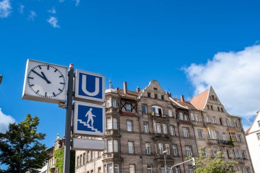 Nuremberg, Almanya, 2 Ağustos 2023. Güneşli bir günde, metro tabelasının fotoğrafı. Saatin ve merdivenlerin sembolünün yanında..