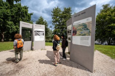 Nuremberg, Almanya, 3 Ağustos 2023. Bir grup turist, Nazi parti mitingi sahasındaki bilgi tabelalarına bakıyor.