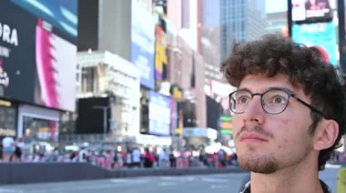 New York City, ABD, 22 Ağustos 2024. Şehir hayatı: kıvırcık saçlı ve gözlüklü beyaz bir adamın portresi. Broadway 'in bulanık arka planına bakıyor..