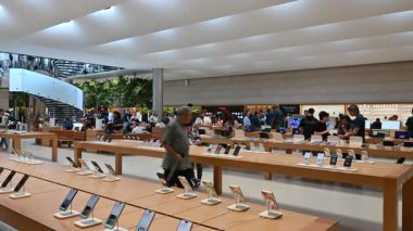 New York, Birleşik Devletler, 22 Ağustos 2024. Apple mağazasındaki kamera görüntüleri: ikonik telefonların geniş ekran görüntüsü ve onlara bakan insanlar.