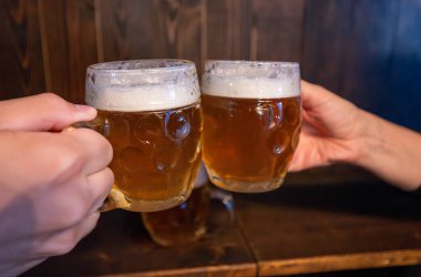 Prag, Çek Cumhuriyeti, 5 Ağustos 2023. Old Town 'da bir birahanede iki bira bardağı kadeh kaldırılır. Bu ulusal bir içecek, şehrin bir sembolü. Neşenin ve birlikte geçirdiğimiz güzel zamanların sembolü.