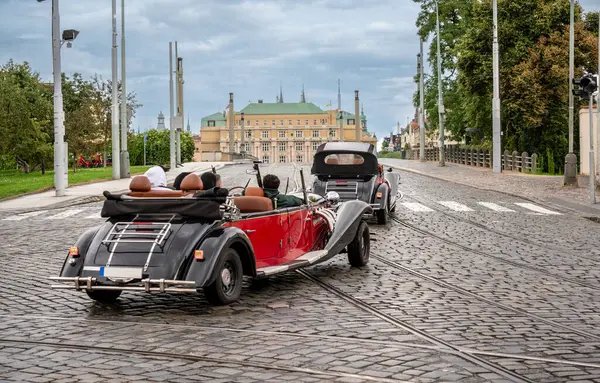 Prag, Çek Cumhuriyeti, 6 Ağustos 2023. Turistler için kiralanan klasik arabalar alternatif bir şekilde şehri keşfediyorlar. Prag 'ı Ziyaret.