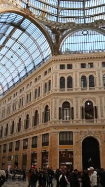 Napoli, İtalya, 27 Aralık 2024. Galleria Umberto I 'in içindeki dikey ekran görüntüsü. Yürüyen insanlar, doğal ışıkla aydınlanan insanlar. Lüks mağazalar ve barlar. Seyahat yerleri.