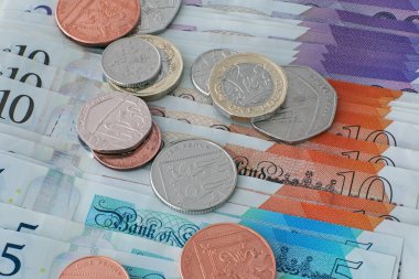 Sterling banknotları ve madeni paralar yığını.