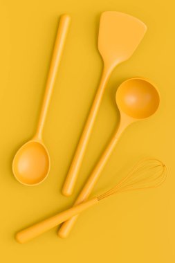 Ahşap mutfak aletleri, aletler ve ekipmanlar sarı monokrom arka planda. Ev yapımı mutfak aletleri ve yemek pişirmek için aksesuarlar