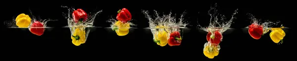 stock image Group of bell pepper falling in water with splash on black background.