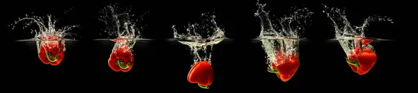 stock image Group of bell pepper falling in water with splash on black background.