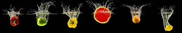 Stock image Group of falling fruits and vegetables in water with splash on black background.