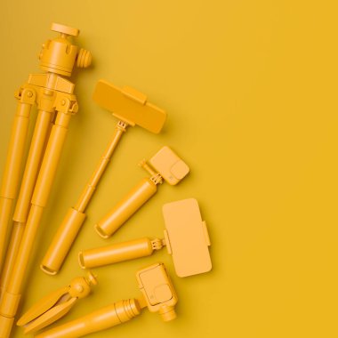 Mevcut olmayan DSLR kamera, cep telefonu, monokrom arka planda selfie çubuğundaki dron ve aksiyon kamerası gibi tasarımcı çalışma alanının ve teçhizatının üst görüntüsü. Canlı yayın için 3D aksesuar hazırlama