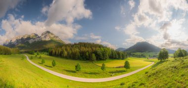 Berchtesgaden Ulusal Parkı, Yukarı Bavyera Alpleri, Almanya, Avrupa 'da gün batımında Hintersee Gölü yakınlarında yol ve bank ile Meadow. Gökyüzü yolu kırpılıyor