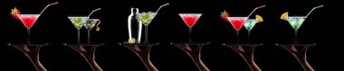 Bira, martini, soda, şampanya, siyah arka planda izole edilmiş viski gibi farklı alkollü kokteyllerle el ele tutuşmalar.