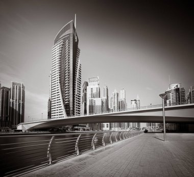 Gökdelenler ve su üzerindeki köprü, siyah-beyaz tarzı, şehir arkaplanı, şehir gelişimi konsepti, Dubai Marina körfezi BAE