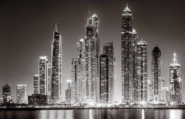 Aydınlatılmış gökdelenleri ve gece siyah beyaz rıhtımlı şehir silüeti, kentsel gelişim konsepti, Dubai Marina Körfezi BAE