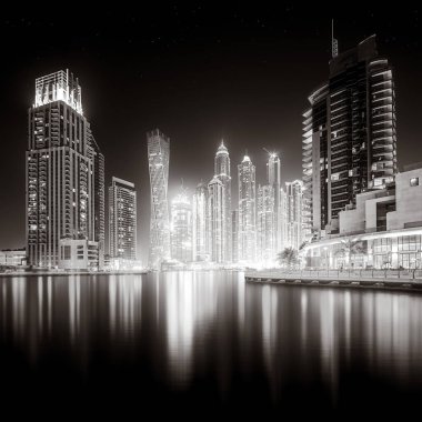 Gökdelenler ve su üzerindeki köprü, siyah-beyaz tarzı, şehir arkaplanı, şehir gelişimi konsepti, Dubai Marina körfezi BAE
