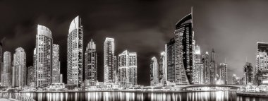 Aydınlatılmış gökdelenleri ve gece siyah beyaz rıhtımlı şehir silüeti, kentsel gelişim konsepti, Dubai Marina Körfezi BAE