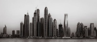 Gökdelenler ve su üzerindeki köprü, siyah-beyaz tarzı, şehir arkaplanı, şehir gelişimi konsepti, Dubai Marina körfezi BAE