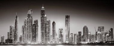 Aydınlatılmış gökdelenleri ve gece siyah beyaz rıhtımlı şehir silüeti, kentsel gelişim konsepti, Dubai Marina Körfezi BAE